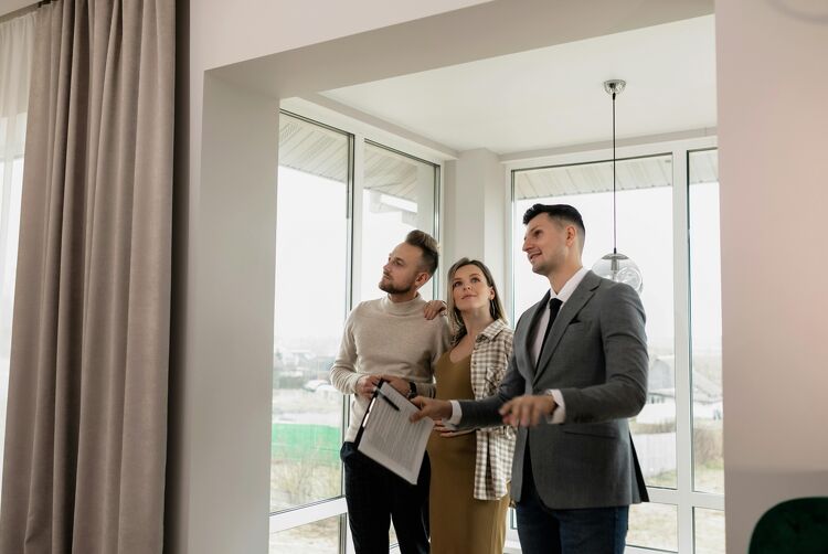 Couple touring a new home with a real estate agent showing them around.
