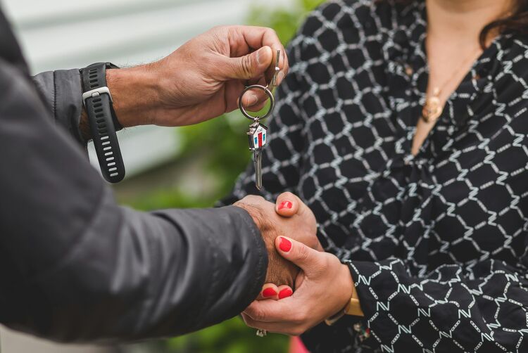 lose-up of a handshake as new homeowners receive their house keys.